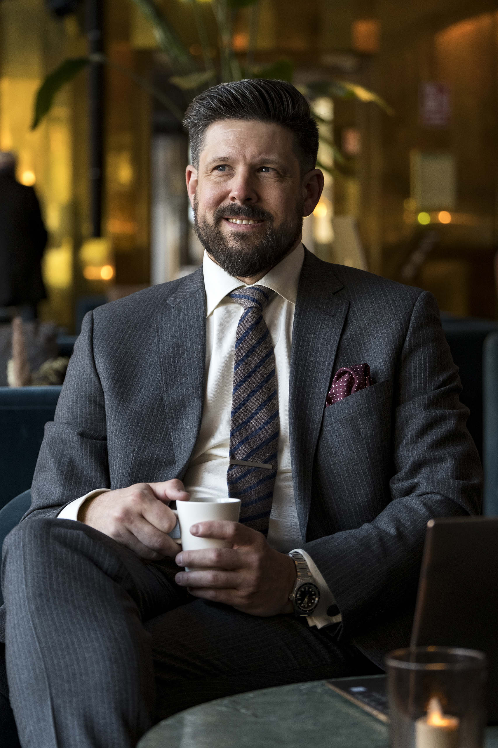 Henric sitter i en fotölj och dricker kaffe. Henric är specialist på avtalsrätt och arbetsrätt.