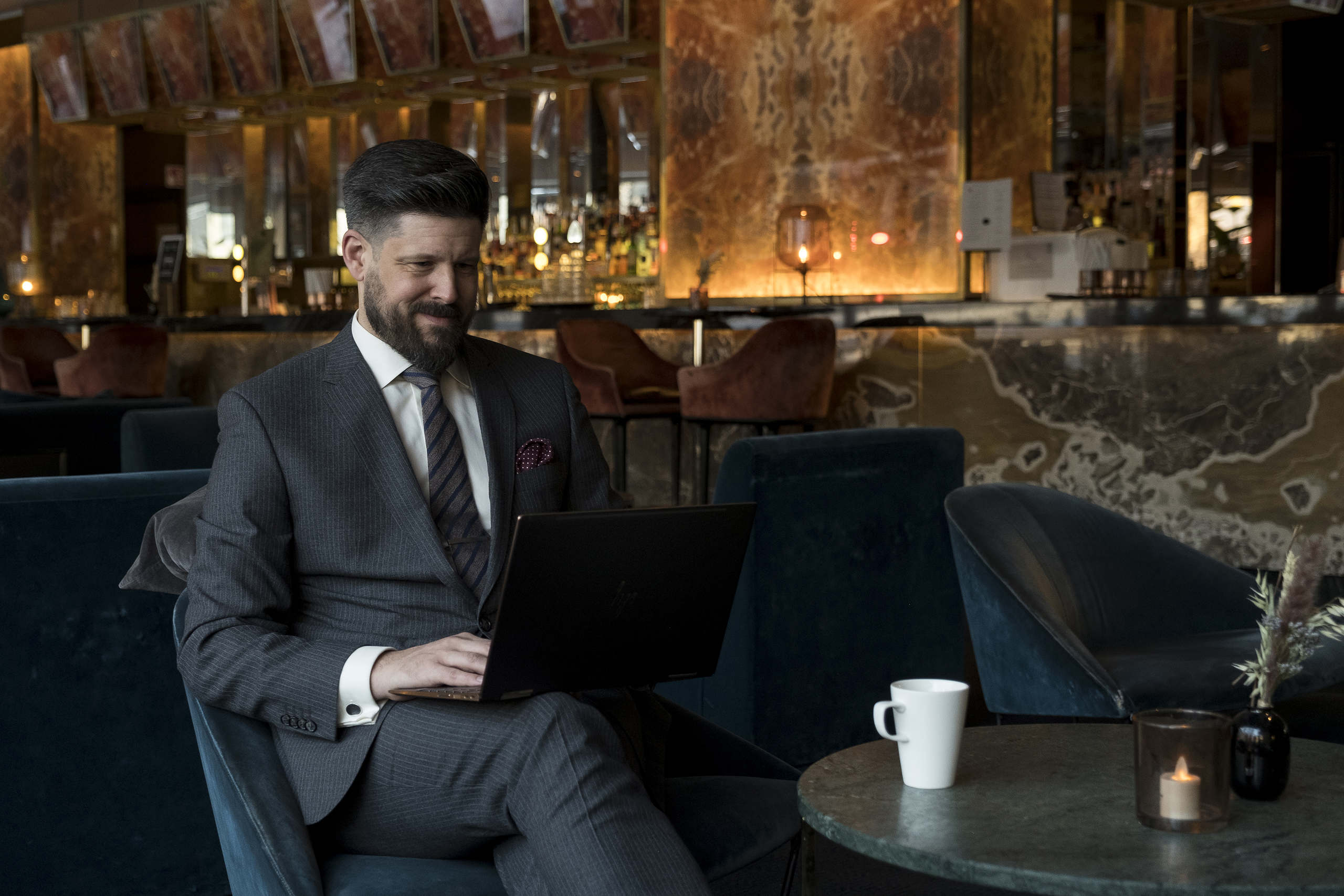 Henric sitter i en fotölj och arbetar. Henric är specialist på avtalsrätt och arbetsrätt.